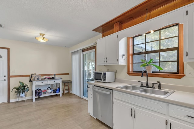 kitchen featuring dishwasher, light wood-type flooring, white cabinets, and sink