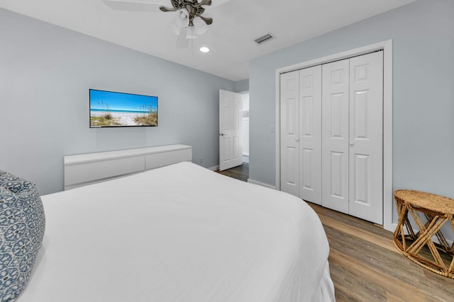 bedroom with hardwood / wood-style floors, ceiling fan, and a closet