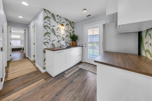 kitchen with dark hardwood / wood-style floors, white cabinetry, and sink