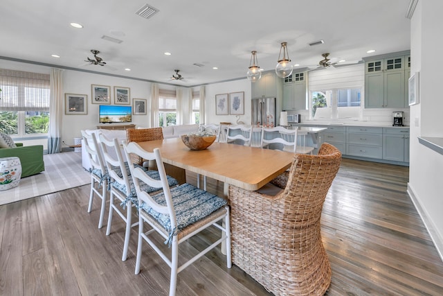 dining area featuring crown molding, a healthy amount of sunlight, ceiling fan, and wood-type flooring