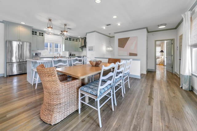 dining room featuring dark wood-type flooring, ceiling fan, and ornamental molding