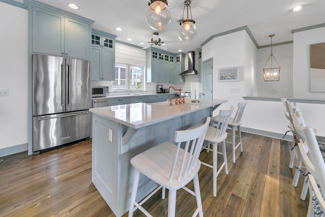 kitchen featuring a kitchen island, high end fridge, dark hardwood / wood-style flooring, crown molding, and hanging light fixtures