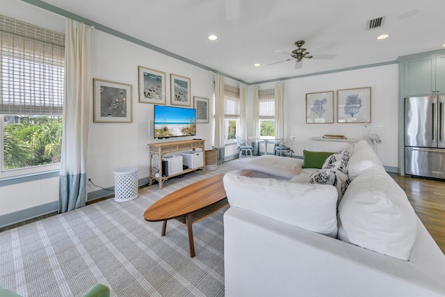 living room featuring ornamental molding, hardwood / wood-style floors, and ceiling fan