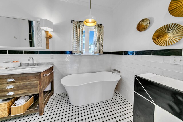 bathroom with a tub to relax in, vanity, tile walls, and crown molding