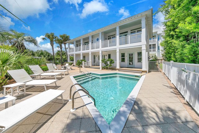 view of swimming pool with french doors and a patio