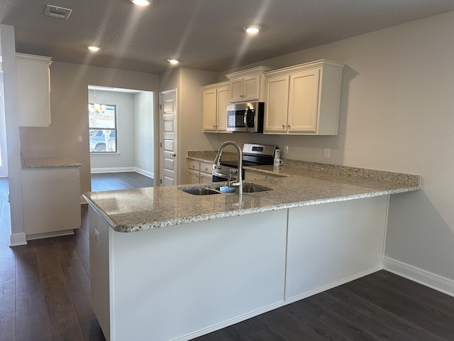 kitchen with sink, kitchen peninsula, white cabinets, and appliances with stainless steel finishes