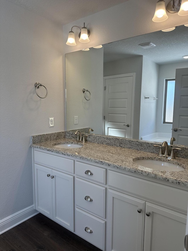 bathroom with vanity, hardwood / wood-style floors, and a bathtub