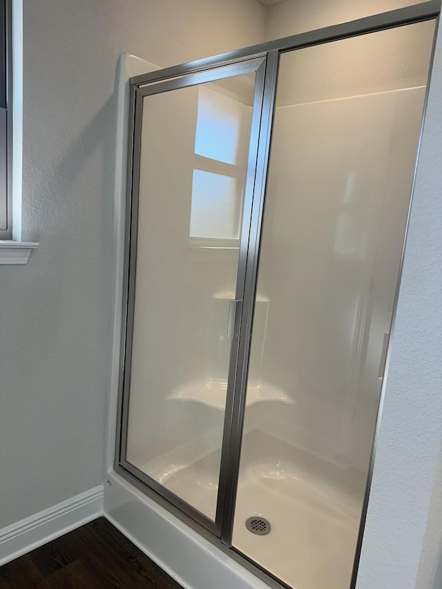 bathroom with hardwood / wood-style floors and an enclosed shower