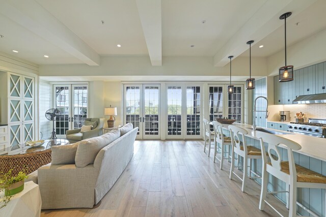 living room featuring sink, beam ceiling, french doors, and light hardwood / wood-style floors