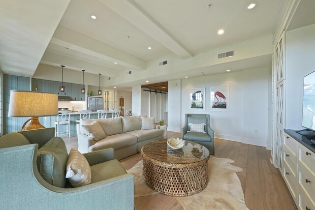 living room with beam ceiling and light hardwood / wood-style floors