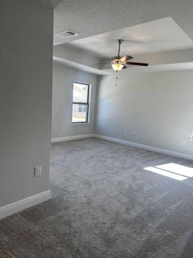 unfurnished room featuring a textured ceiling, carpet floors, ceiling fan, and baseboards