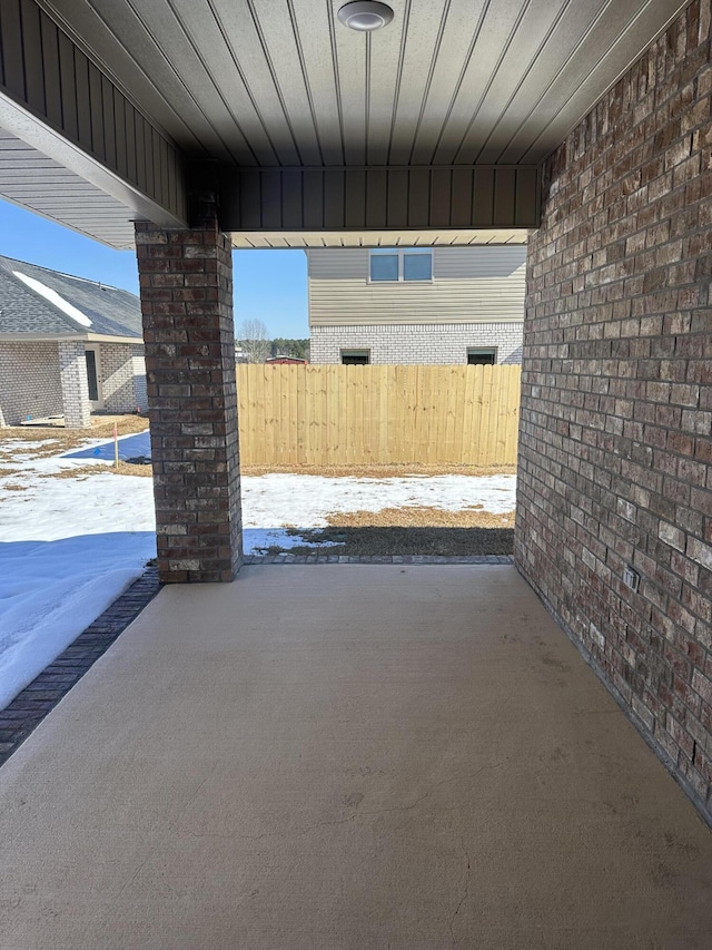 snow covered patio featuring fence