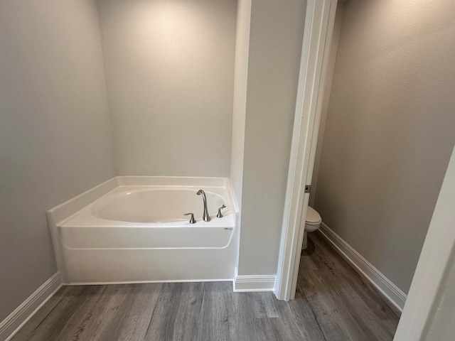 bathroom featuring hardwood / wood-style floors, a bathing tub, and toilet