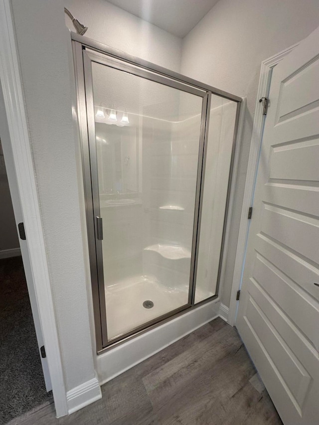 bathroom with wood-type flooring and walk in shower