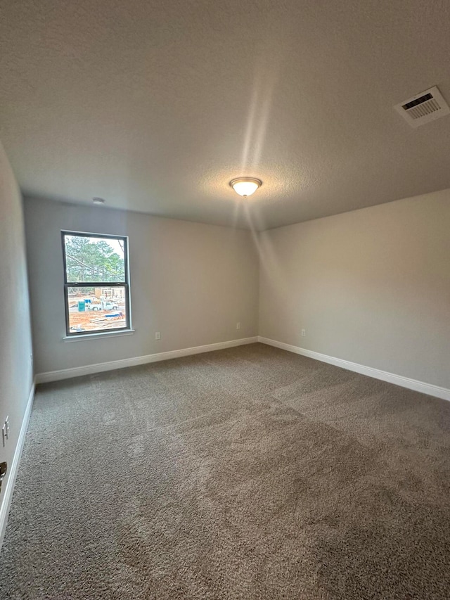 carpeted empty room with a textured ceiling