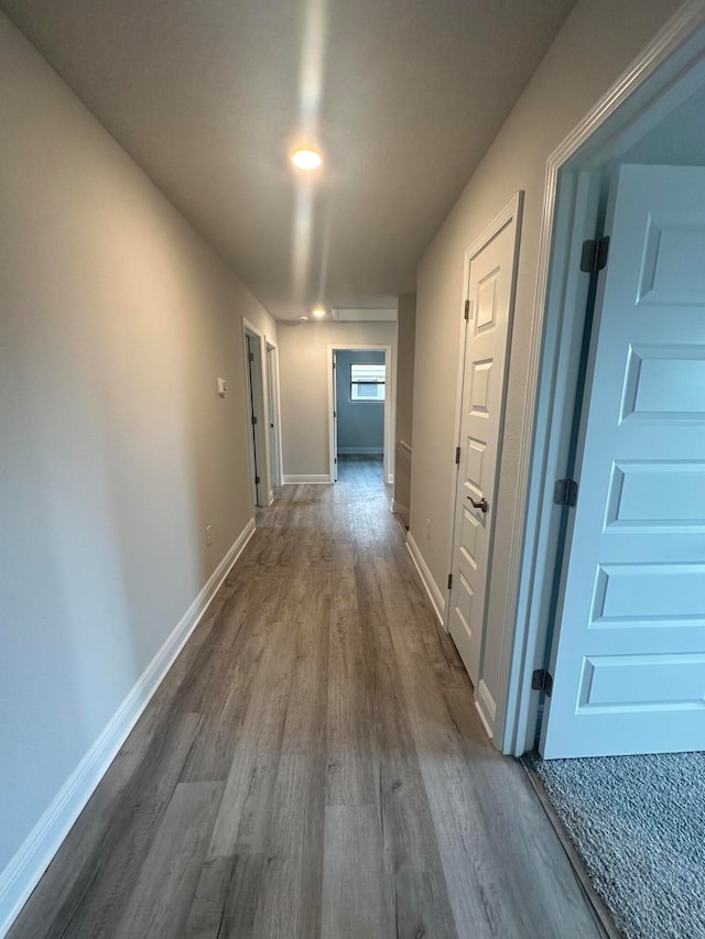 hallway with hardwood / wood-style flooring