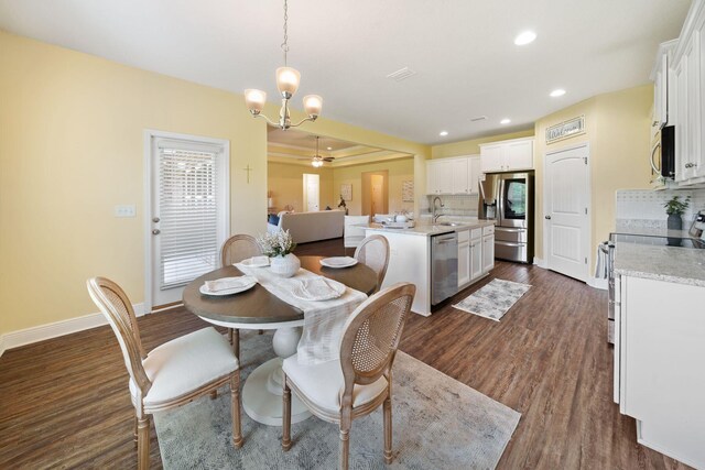 dining room featuring dark hardwood / wood-style flooring, sink, and a chandelier