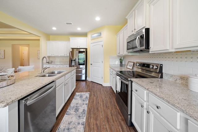 kitchen featuring stainless steel appliances, dark hardwood / wood-style floors, tasteful backsplash, sink, and light stone counters