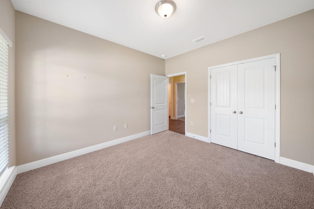 unfurnished bedroom with carpet floors and a closet