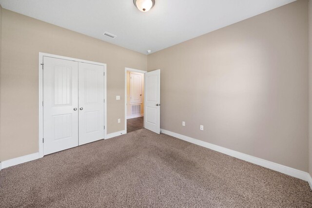 unfurnished bedroom featuring carpet flooring and a closet