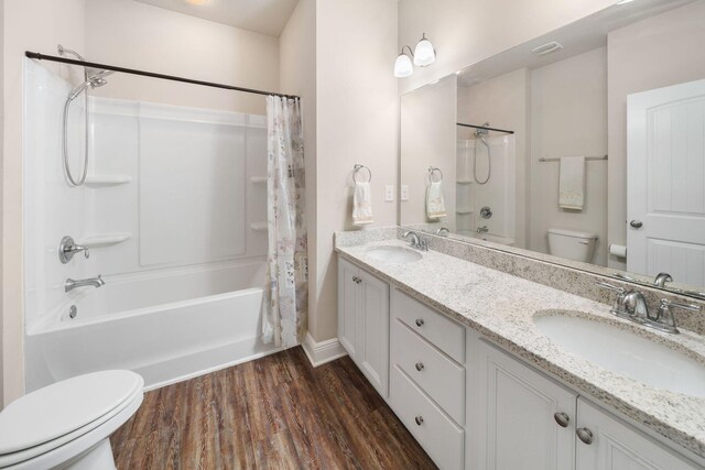 full bathroom with shower / tub combo, wood-type flooring, toilet, and dual bowl vanity