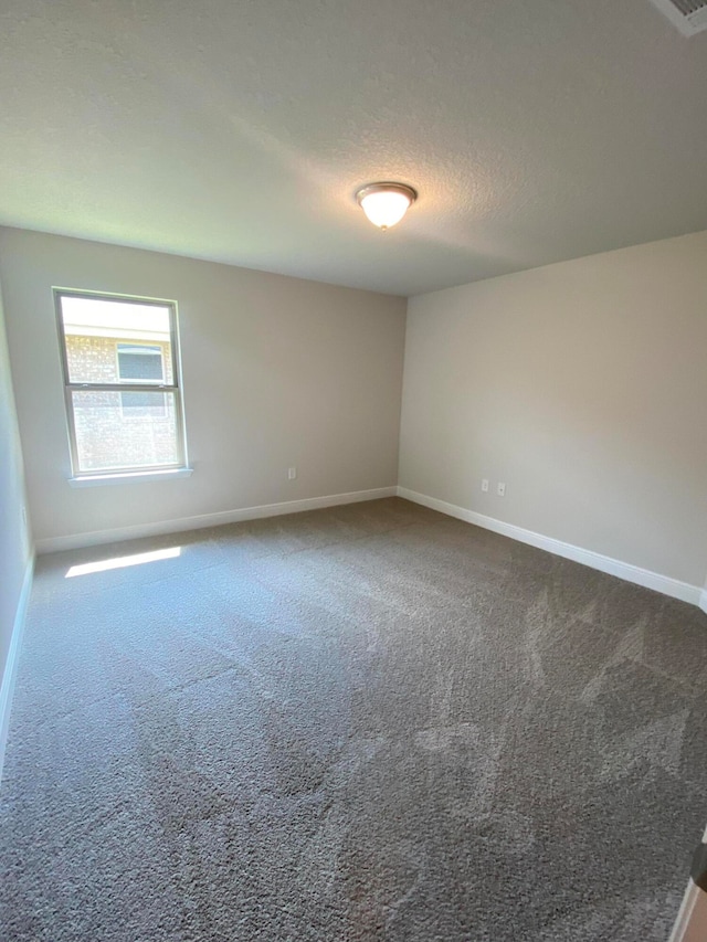 carpeted spare room featuring a textured ceiling