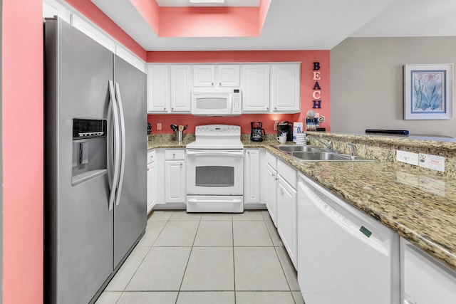 kitchen featuring white appliances, light tile patterned floors, white cabinets, and a sink