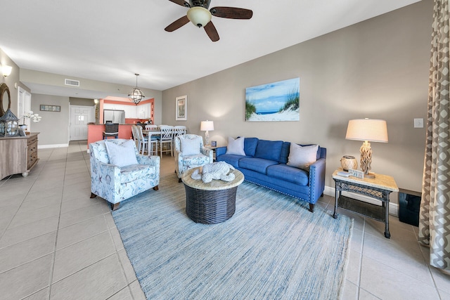 living room with light tile patterned floors, a ceiling fan, visible vents, and baseboards