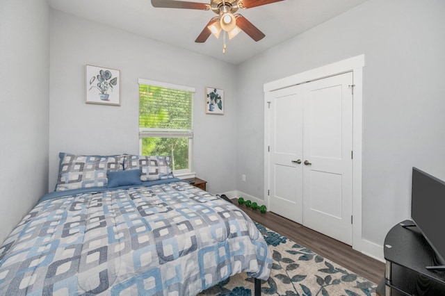 bedroom with dark hardwood / wood-style flooring, a closet, and ceiling fan