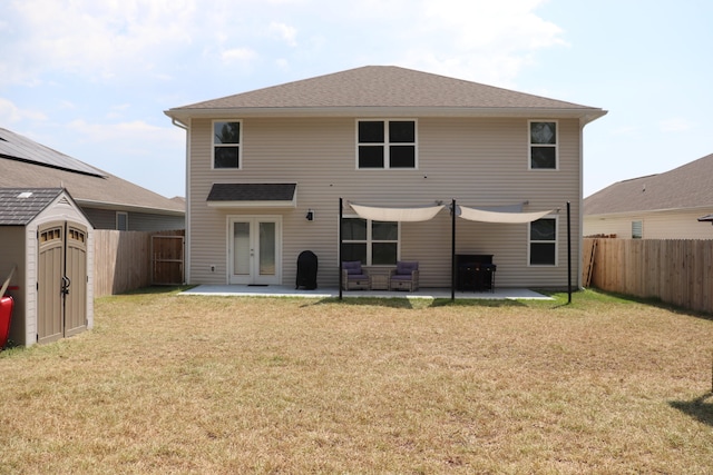 rear view of property featuring solar panels, a yard, and a patio