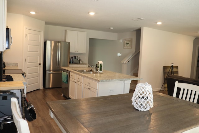 kitchen with sink, appliances with stainless steel finishes, white cabinets, and dark hardwood / wood-style flooring