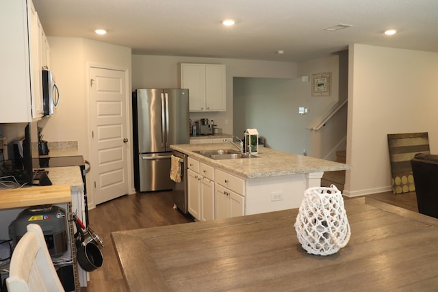 kitchen with sink, white cabinets, dark wood-type flooring, and stainless steel appliances