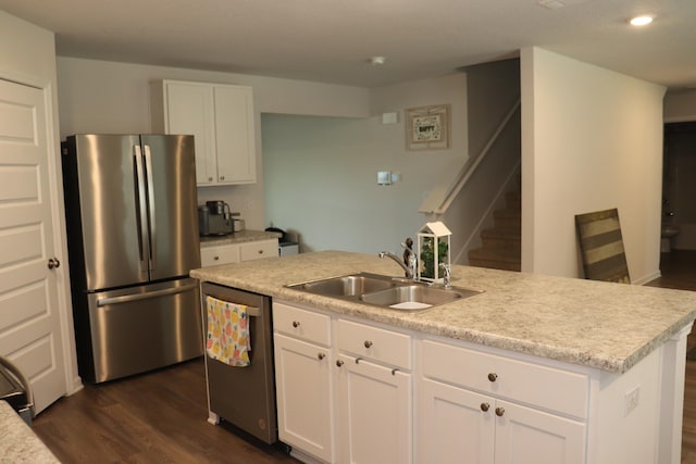 kitchen with sink, dark hardwood / wood-style flooring, stainless steel appliances, a center island with sink, and white cabinets