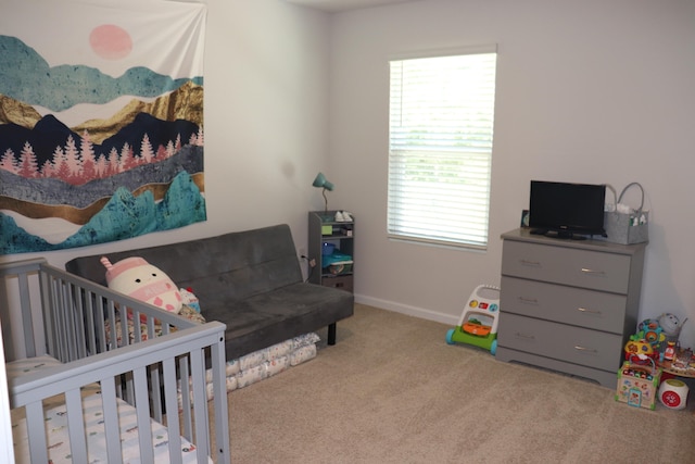 bedroom featuring a crib and carpet