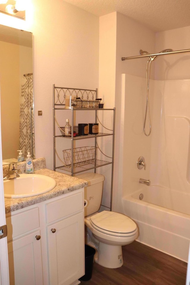 full bathroom featuring shower / bathing tub combination, vanity, a textured ceiling, toilet, and hardwood / wood-style flooring