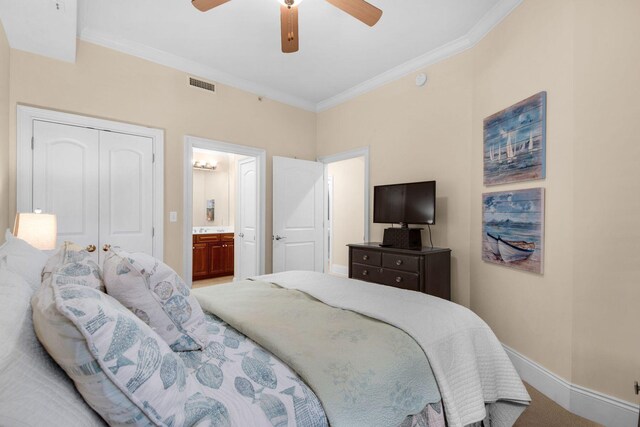 carpeted bedroom with ceiling fan, a closet, ensuite bath, and ornamental molding