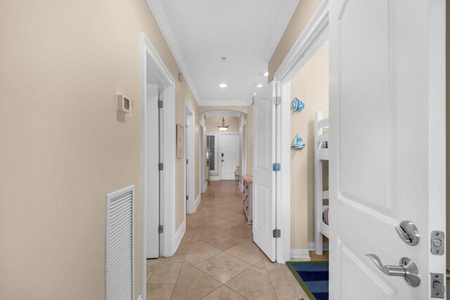 corridor with crown molding and light tile patterned flooring