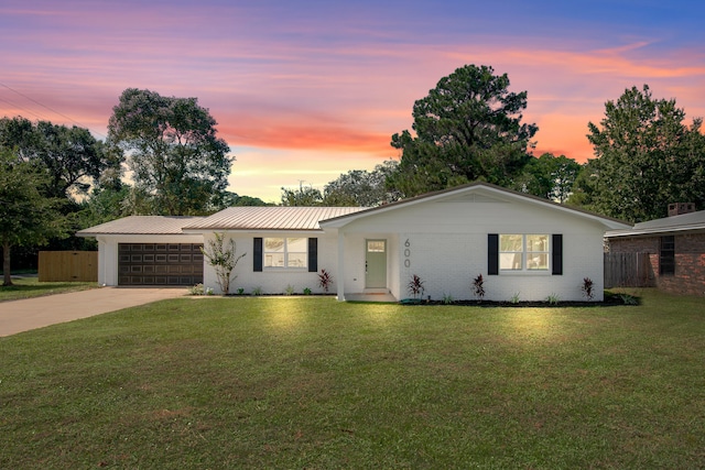 ranch-style house with a yard and a garage