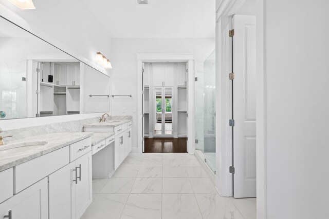 bathroom with tile patterned flooring, a shower with shower door, and vanity