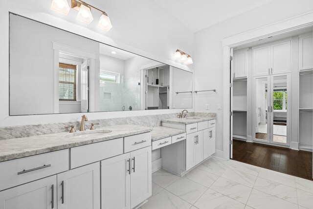 bathroom featuring hardwood / wood-style flooring, a shower with door, and vanity