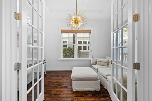 living area with dark wood-type flooring, french doors, and a chandelier