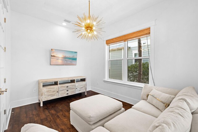 living room featuring a notable chandelier and dark wood-type flooring