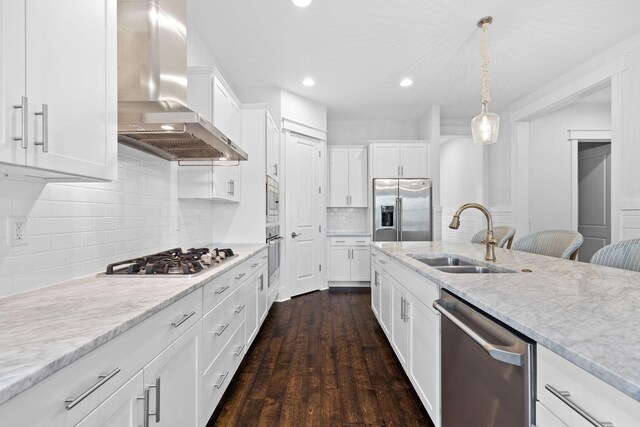 kitchen with stainless steel appliances, decorative backsplash, wall chimney exhaust hood, sink, and dark hardwood / wood-style flooring