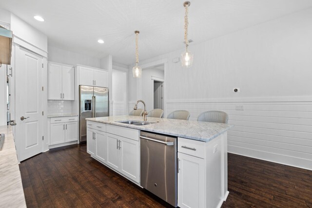 kitchen featuring appliances with stainless steel finishes, a center island with sink, dark hardwood / wood-style floors, and sink