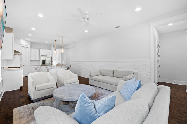 living room with ceiling fan, sink, and dark hardwood / wood-style flooring