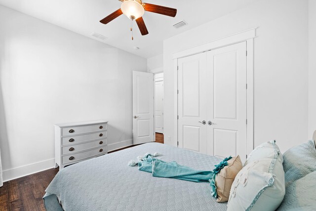 bedroom with dark hardwood / wood-style flooring, a closet, and ceiling fan