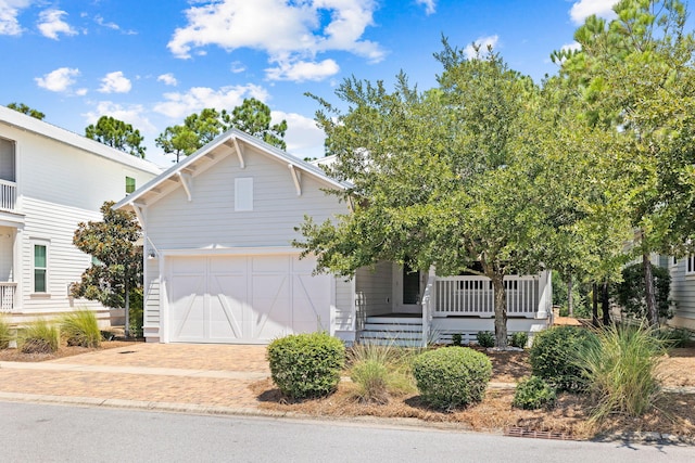 view of front of property featuring a garage, a porch, and driveway