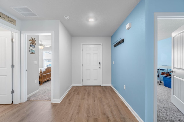 entrance foyer featuring ceiling fan and light carpet