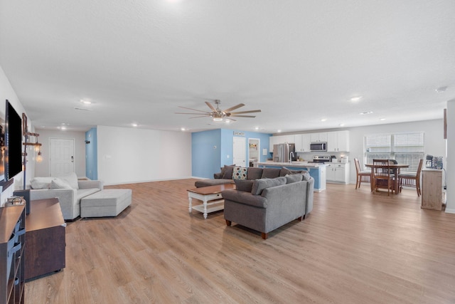 living room with ceiling fan and light hardwood / wood-style floors