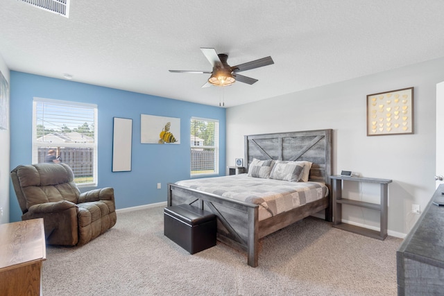 carpeted bedroom featuring a textured ceiling and ceiling fan